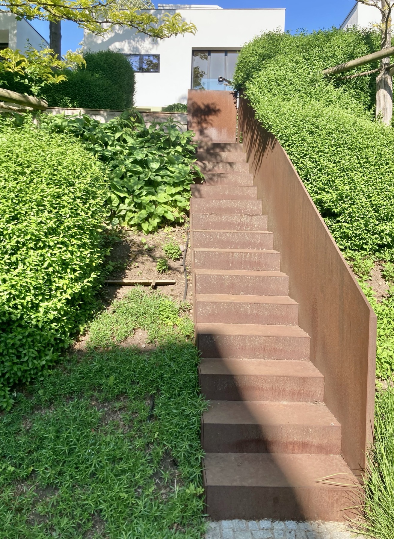 Escalier extérieur en acier Corten dans un jardin en pente